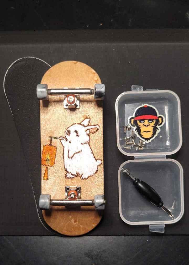 Custom handmade fingerboard deck with white rabbit graphic and miniature skate tools.