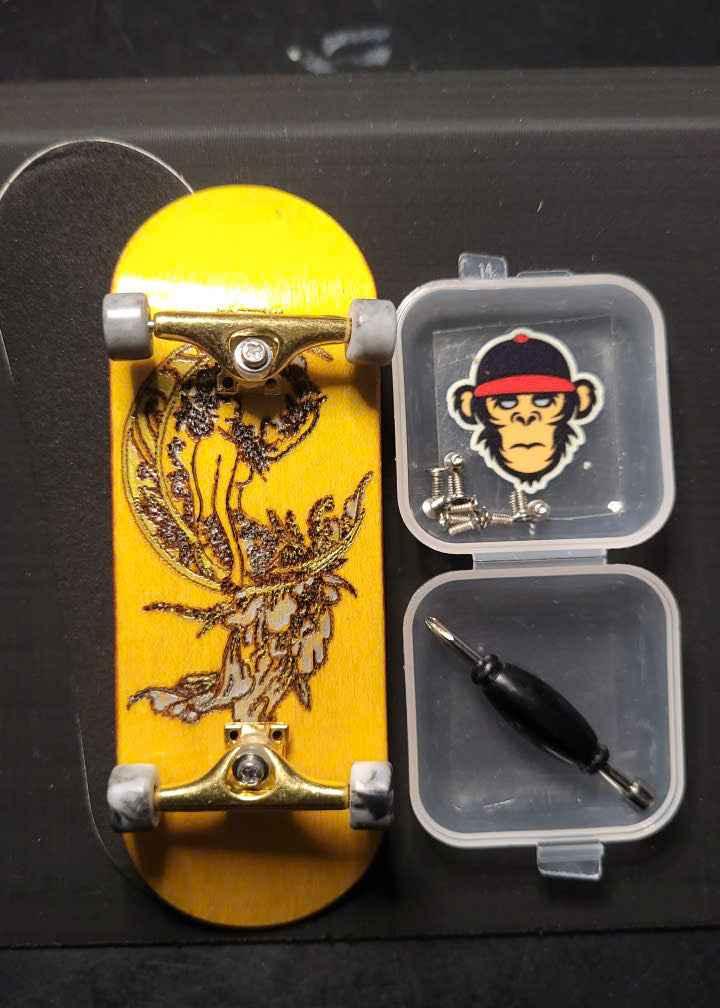 Custom yellow fingerboard deck with gold trucks and a small tool kit accessory.