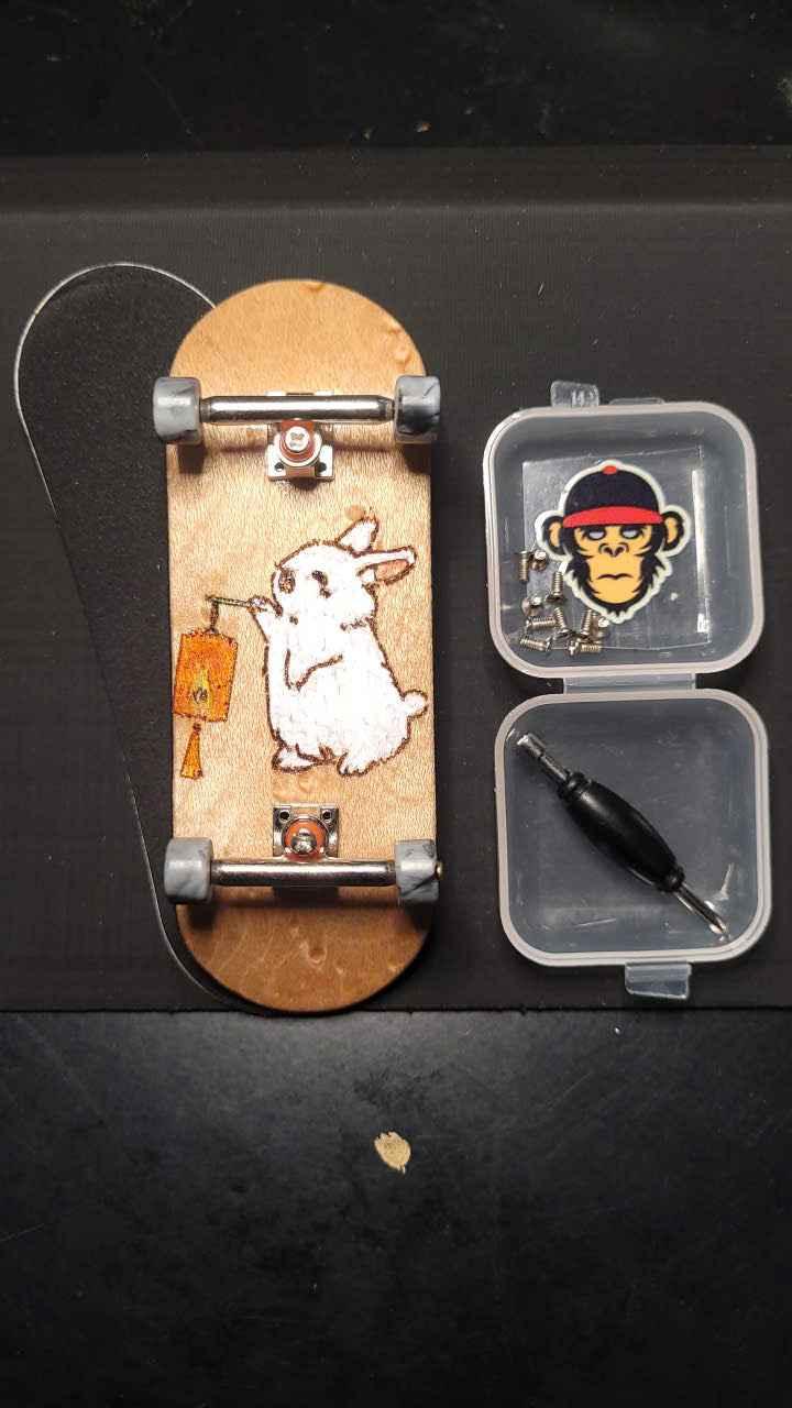 Custom handmade fingerboard deck with white rabbit graphic and mini skate tool kit.