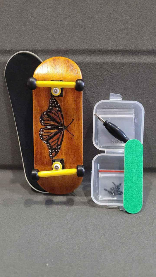 Custom wooden fingerboard with butterfly graphic and miniature skate tools.