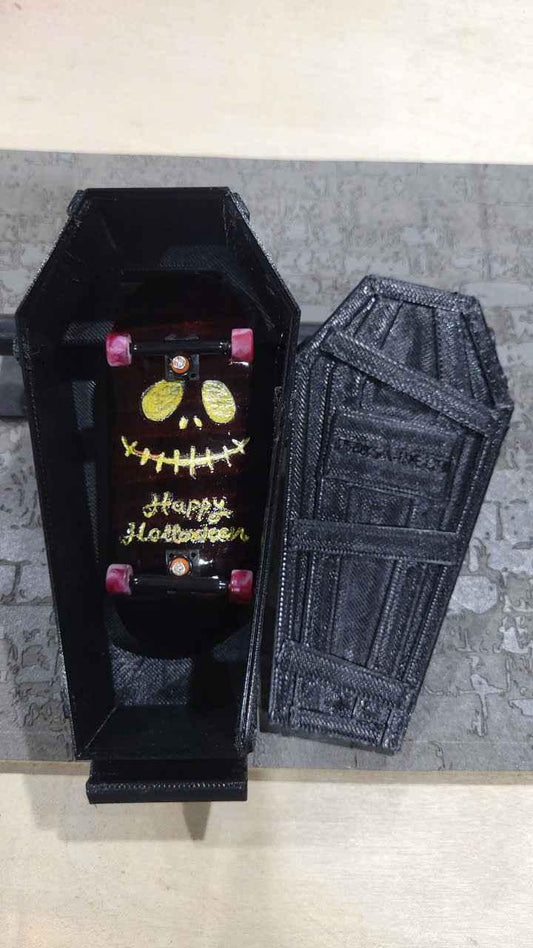 Custom Halloween fingerboard deck with skull design inside a miniature black coffin.