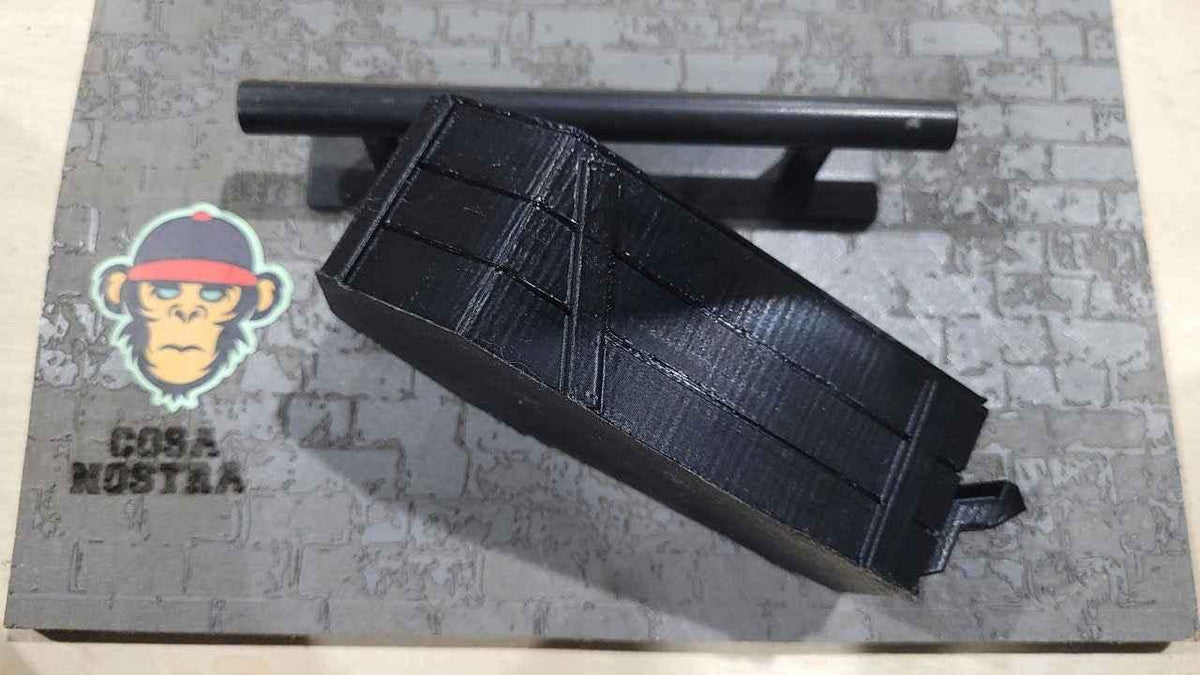 Black 3D printed fingerboard rail and grind obstacle on a brick pattern base.