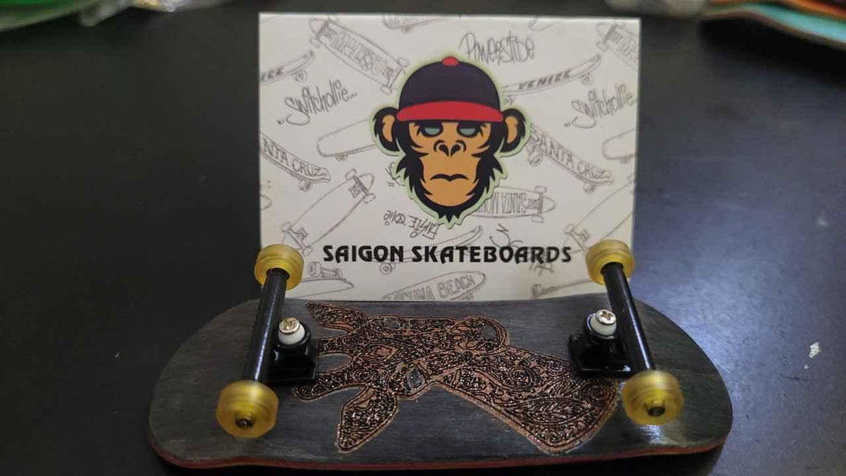 Custom handmade fingerboard deck with intricate copper pattern and gold wheels.