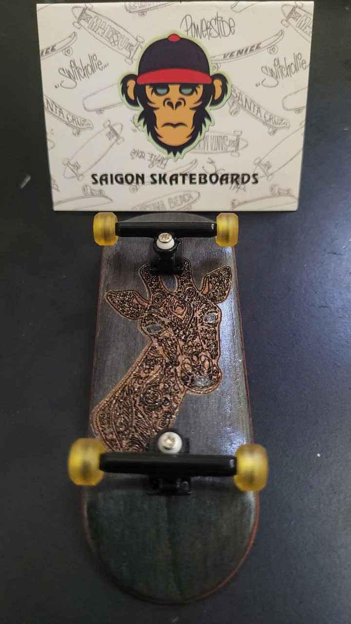 Custom handmade fingerboard deck with a detailed giraffe graphic and yellow wheels.