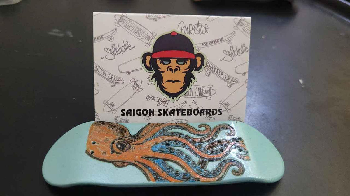 Custom handmade fingerboard deck with an octopus graphic and Saigon Skateboards card.