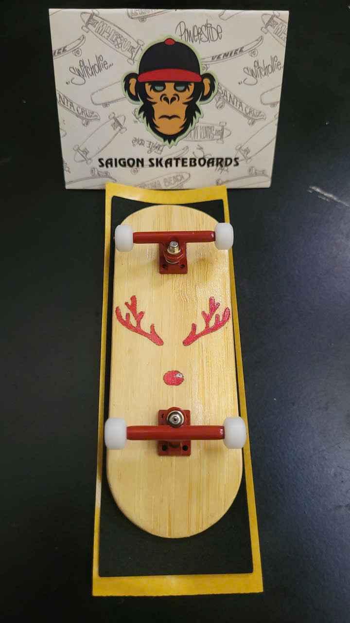 Custom handmade fingerboard deck with red reindeer graphic and white wheels.