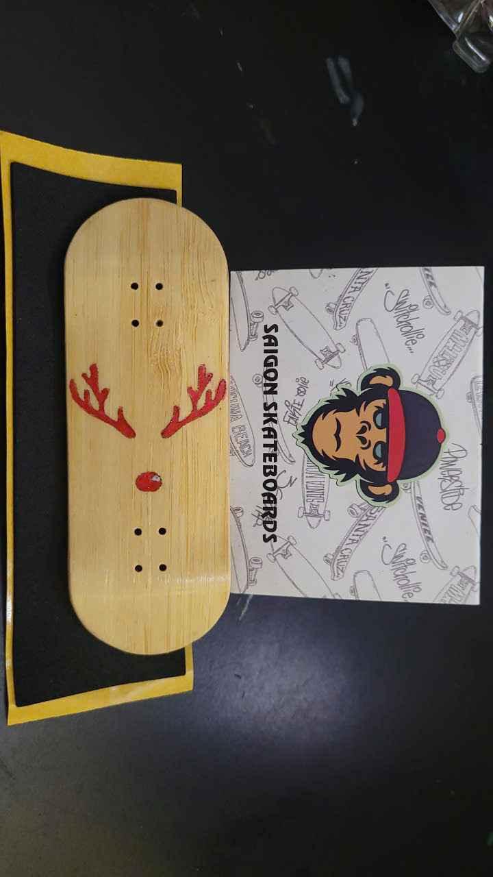 Handmade wooden fingerboard deck with red reindeer graphic and brand sticker.