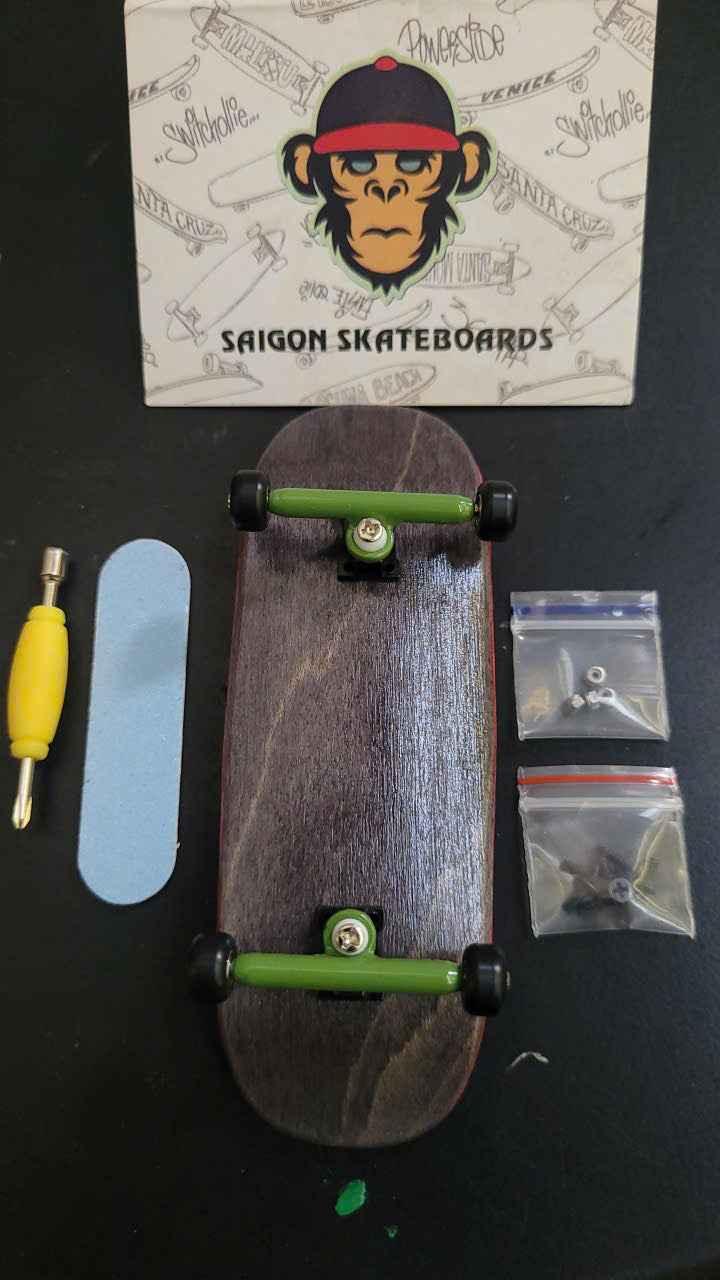 Custom fingerboard kit with dark wood deck, green trucks, grip tape, and tools.