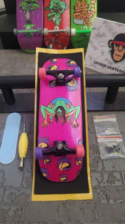 Custom handmade pink fingerboard deck with monster graphic and pink wheels.