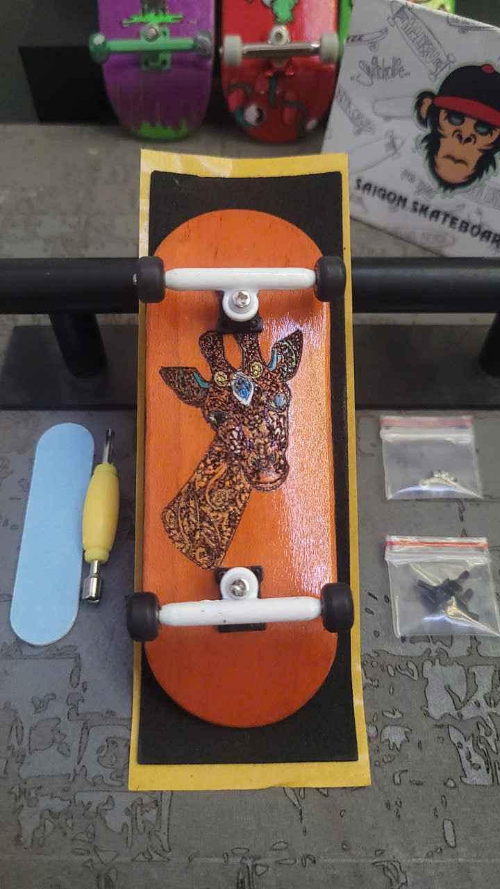 Custom handmade fingerboard deck with giraffe graphic and white trucks.