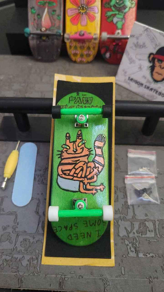 Custom handmade fingerboard deck with orange cat graphic and green trucks.
