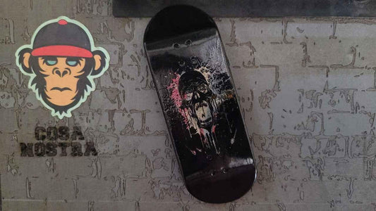 Custom handmade fingerboard deck with a dark skull graphic on a black background.