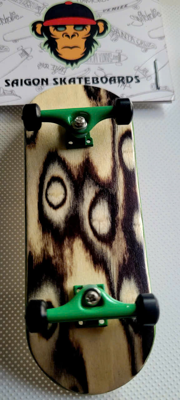 Fingerboard with streak-pattern wooden deck, green trucks, and black wheels
