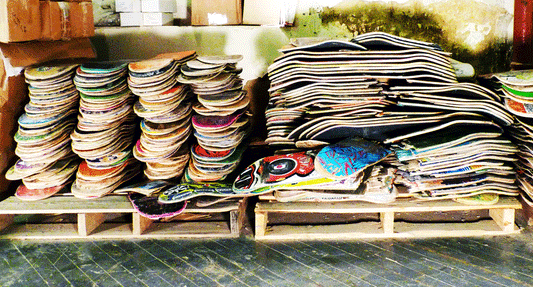 Broken skateboard decks stacked on pallets — symbolizing the disposable product-first culture harming Vietnam’s skate scene