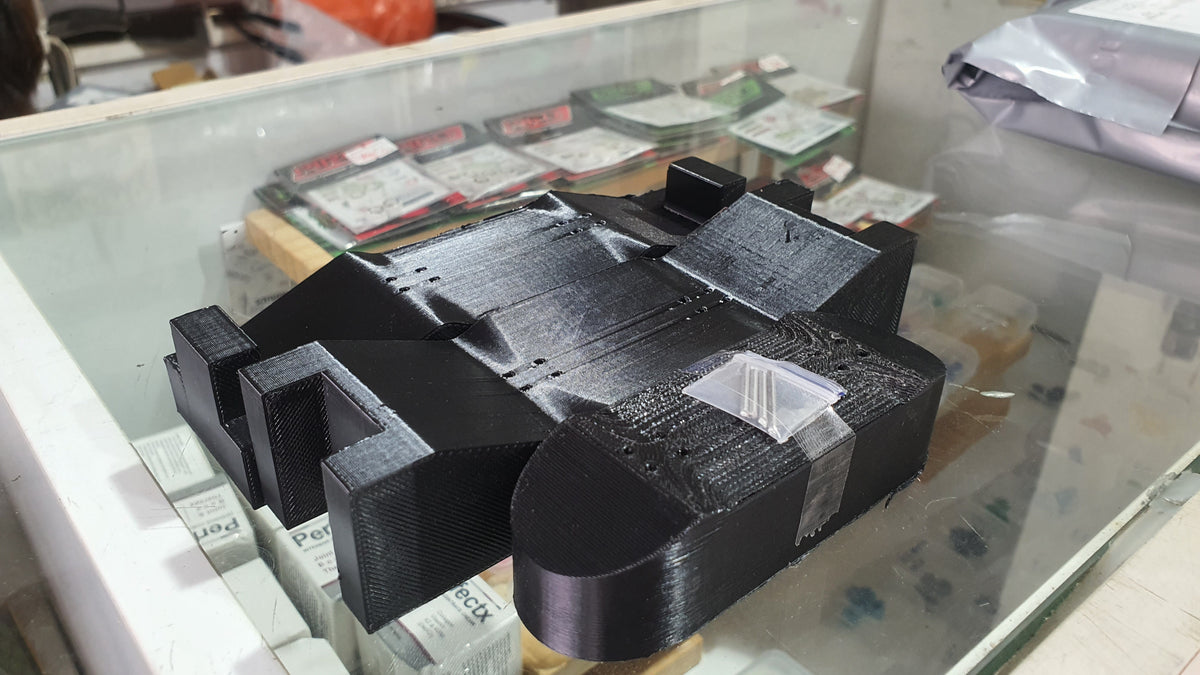 Black 3D-printed custom mold with raised blocks and curved end