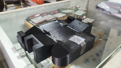 Black 3D-printed custom mold with raised blocks and curved end