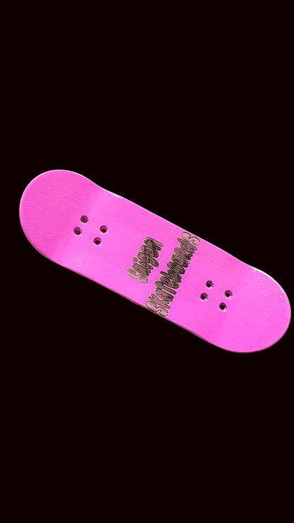 Pink fingerboard deck with dark logo text and bolt holes