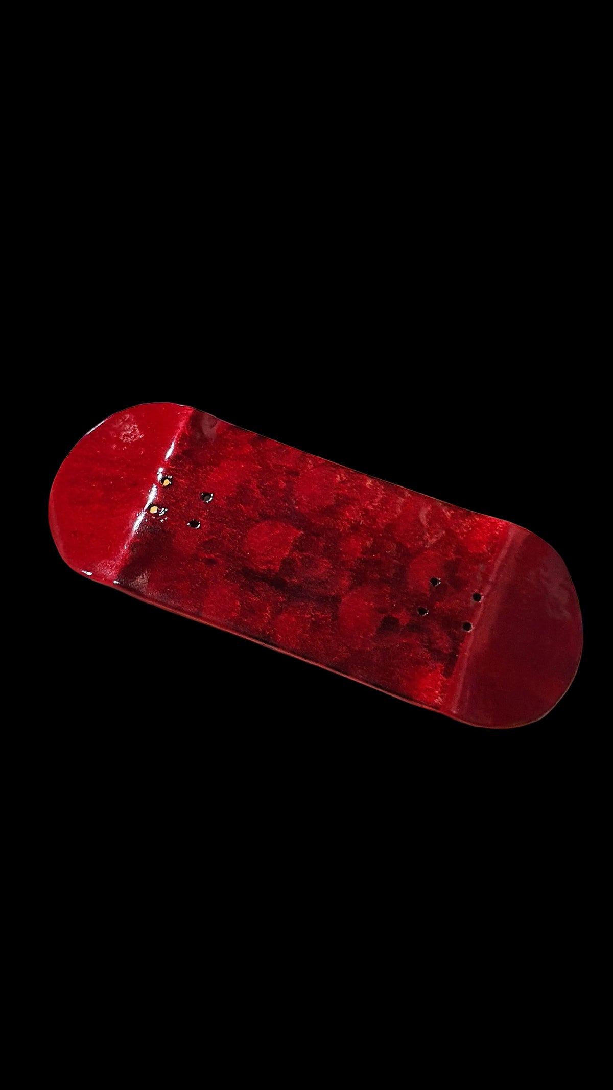 Red fingerboard deck angled side view, curved nose and tail.