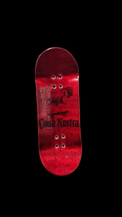 Red fingerboard deck with graphic top and four metal mounting holes.