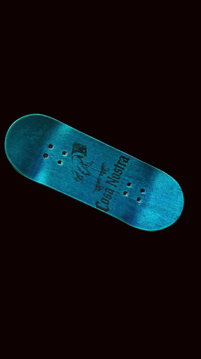 Blue teal fingerboard deck, angled view with graphic center and six mounting holes.