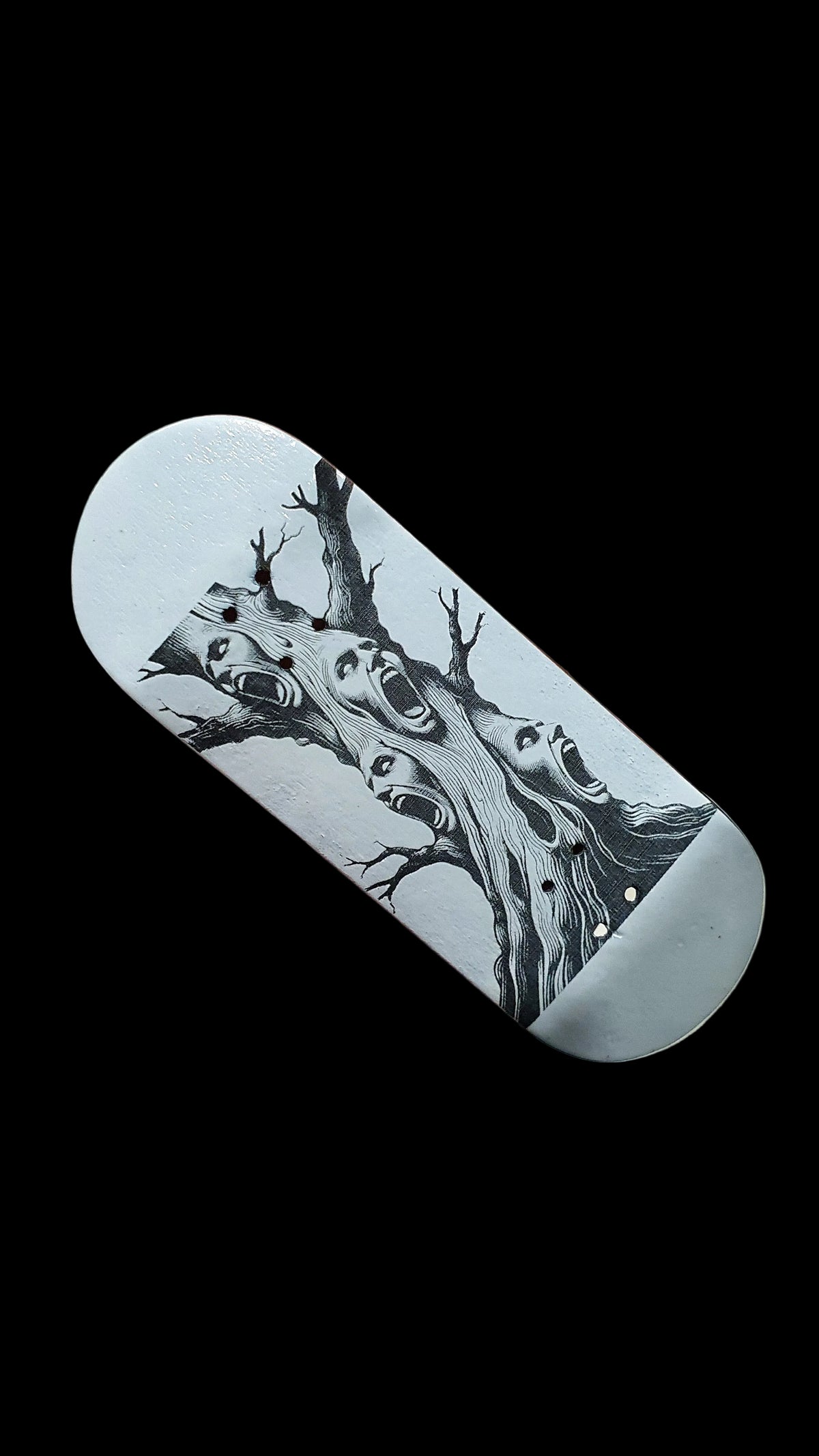 Light gray skateboard deck with black-and-white tree and screaming faces graphic