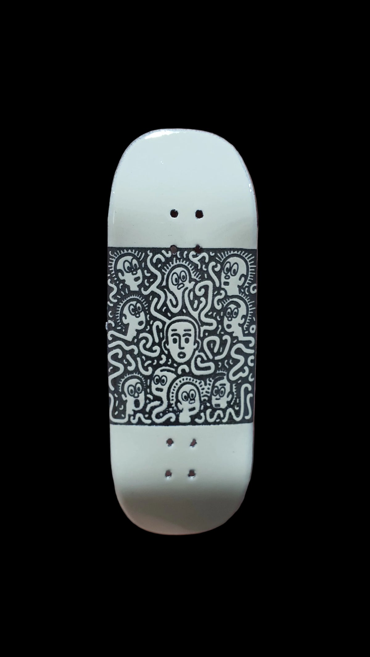 Saigon Skateboards Confusion fingerboard deck, white with black illustrated graphics and four mounting holes