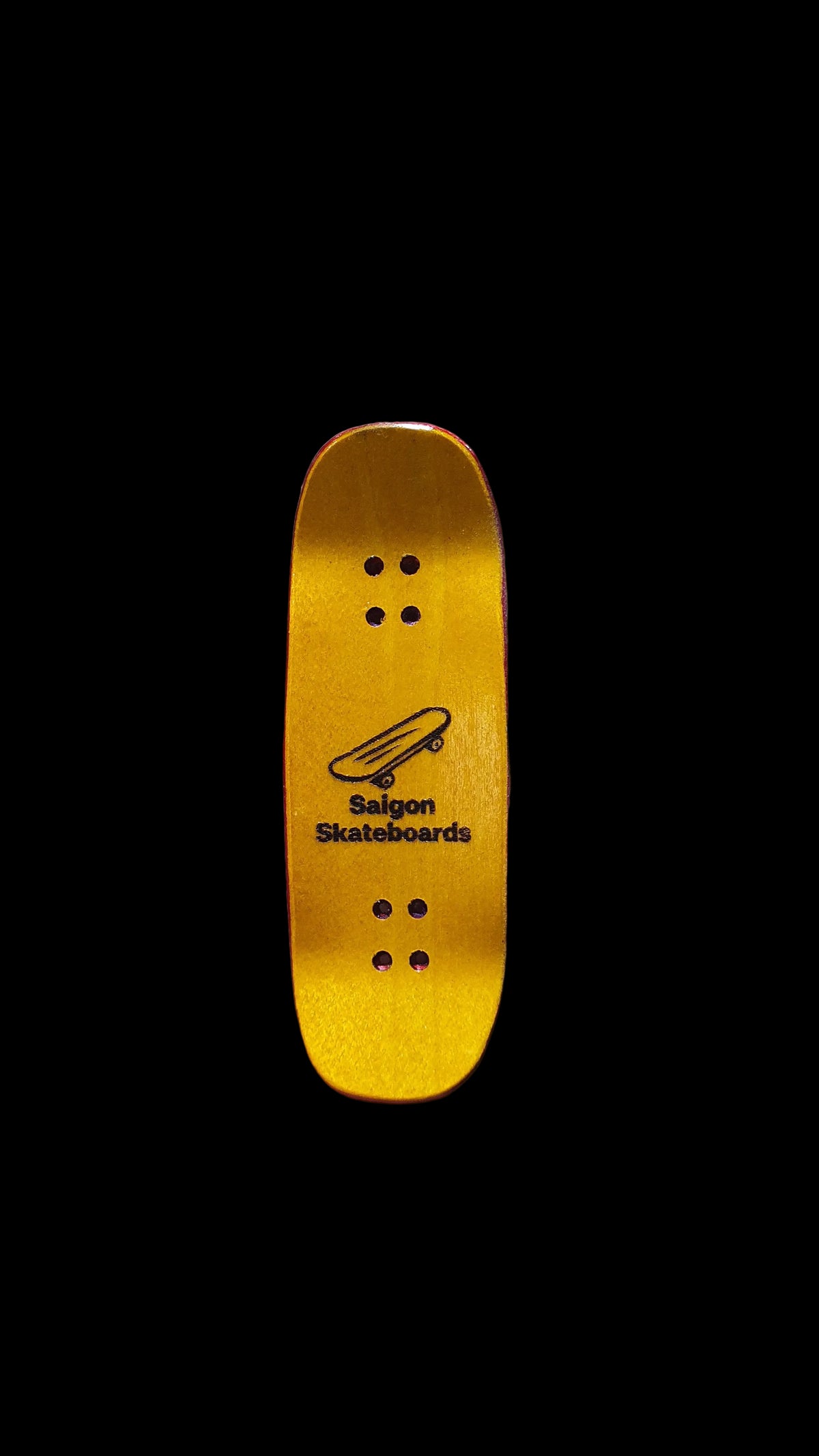 Yellow maple underside of a Saigon Skateboards fingerboard deck with logo and mounting holes