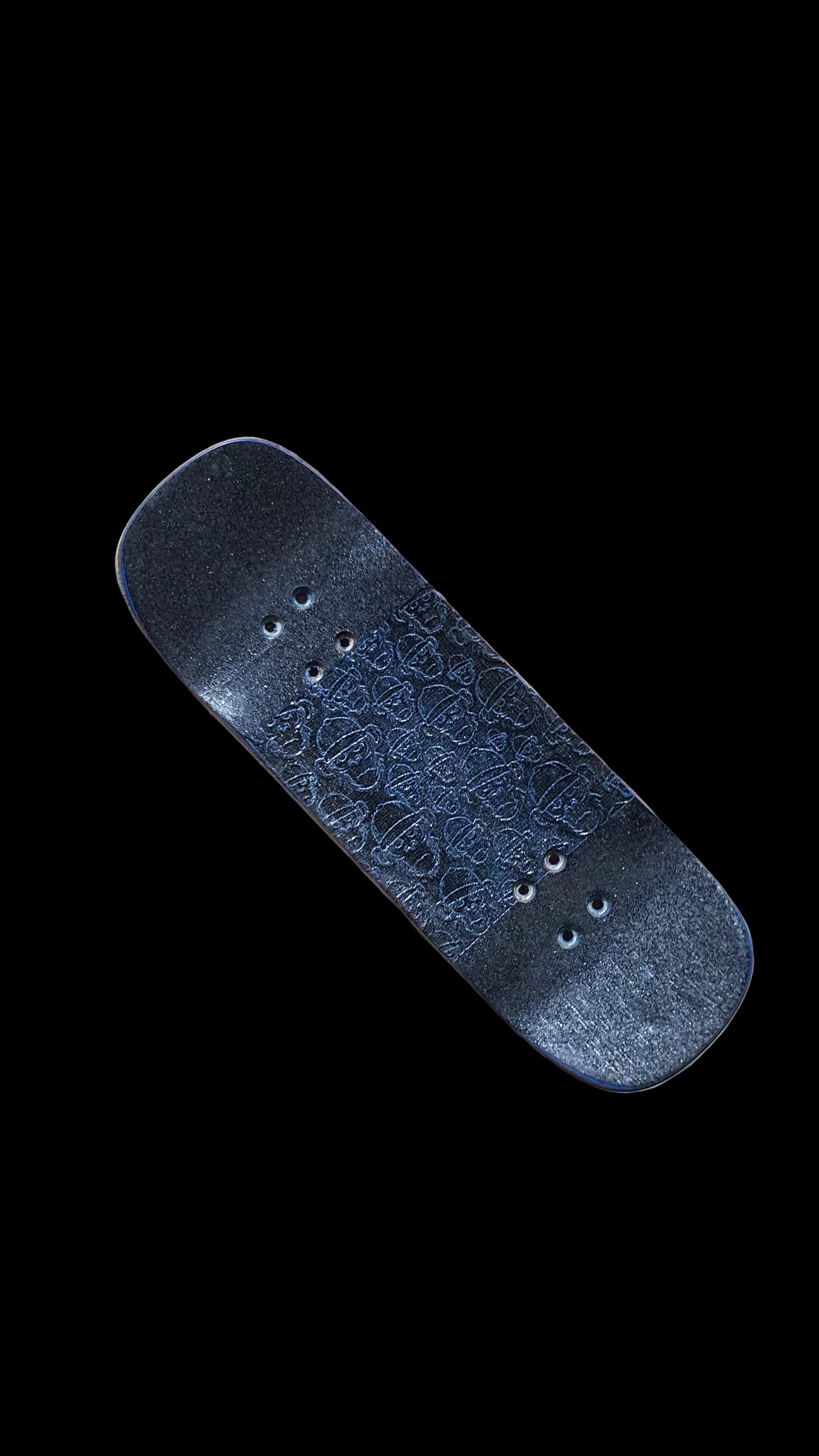 Angled view of the fingerboard deck top with blue patterned grip and mounting holes