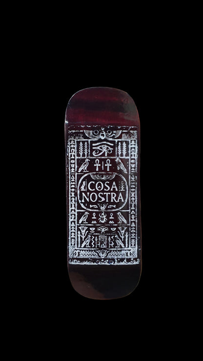 Cosa Nostra fingerboard deck with ornate white graphic on a dark red-brown surface