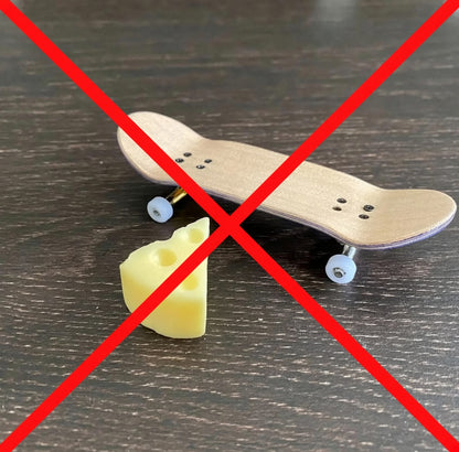 Yellow skateboard wax cube on tabletop near a skateboard deck