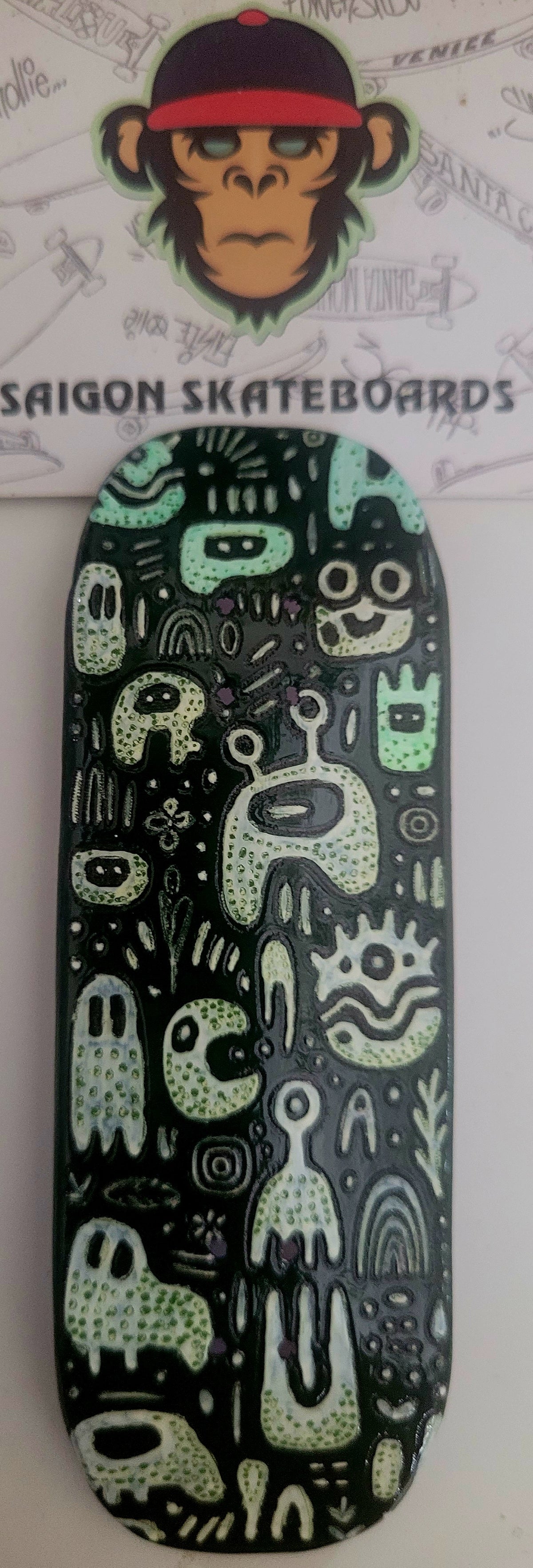 Medium fingerboard deck with cute monster graphic, dark green and black