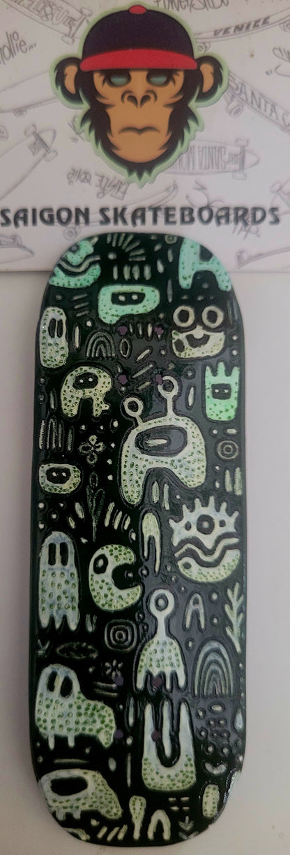 Medium fingerboard deck with cute monster graphic, dark green and black