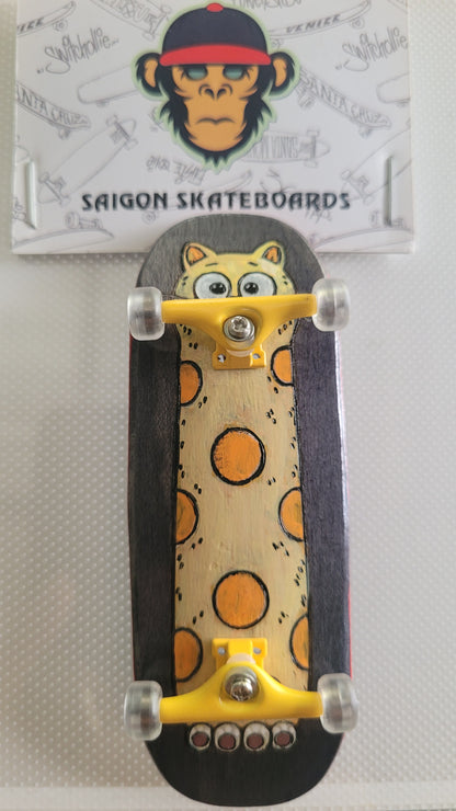 Complete fingerboard with cat-themed deck, clear wheels, and yellow trucks