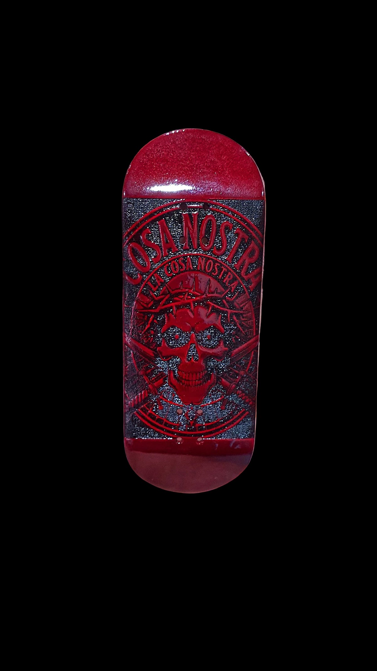 Red fingerboard deck with Cosa Nostra skull graphic on dark panel