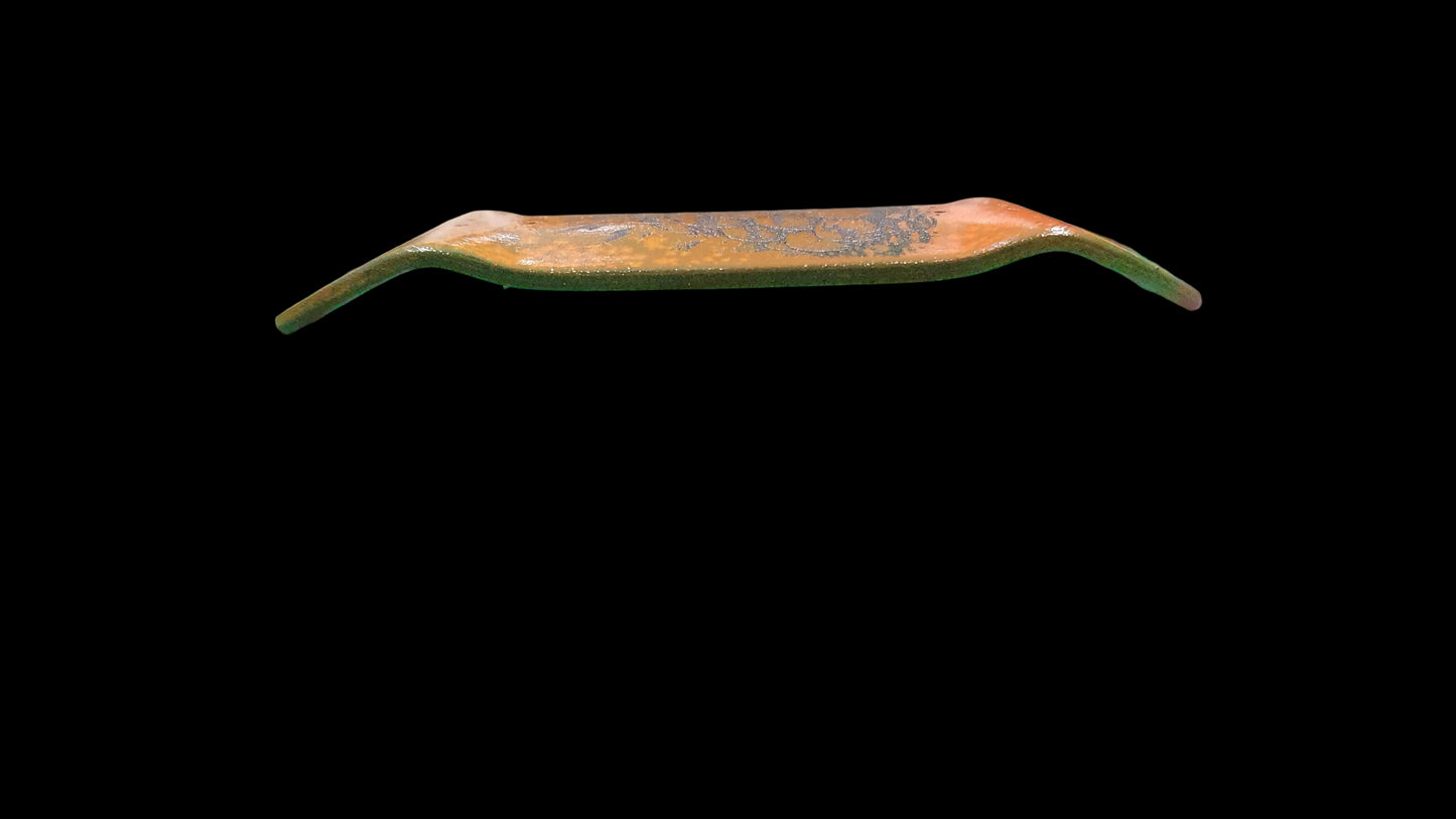 Close-up of a green surface with a small black object on it, blurred background