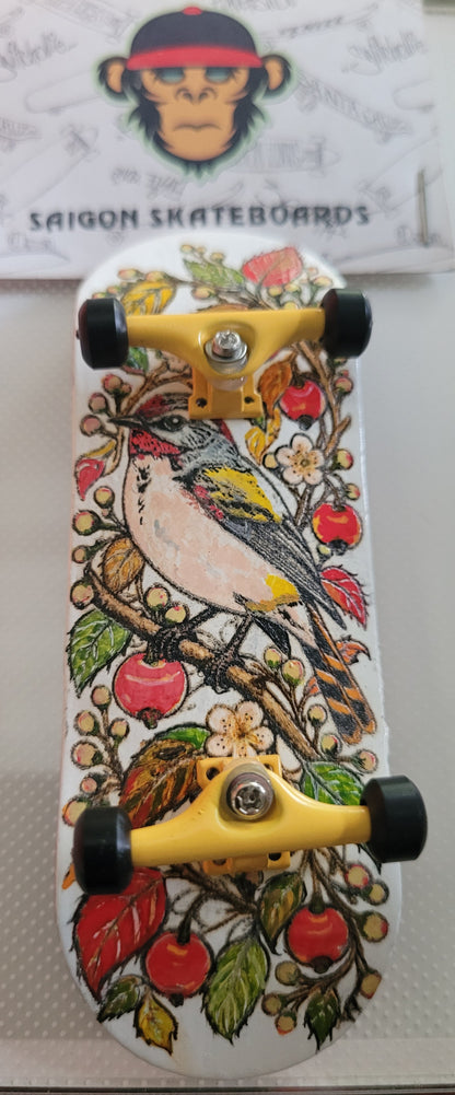 Top view of complete finger skateboard, bird floral and cherry graphic deck