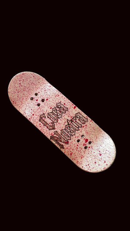 Popsicle fingerboard deck, pink speckled finish with black graffiti-style graphic