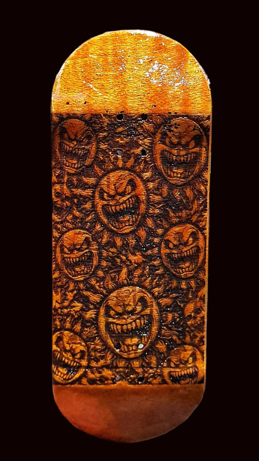 Fingerboard deck top view, orange-brown with dense dark graphic faces pattern