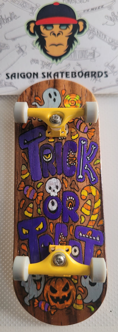 Complete skateboard with orange Halloween deck art, silver trucks, and white wheels