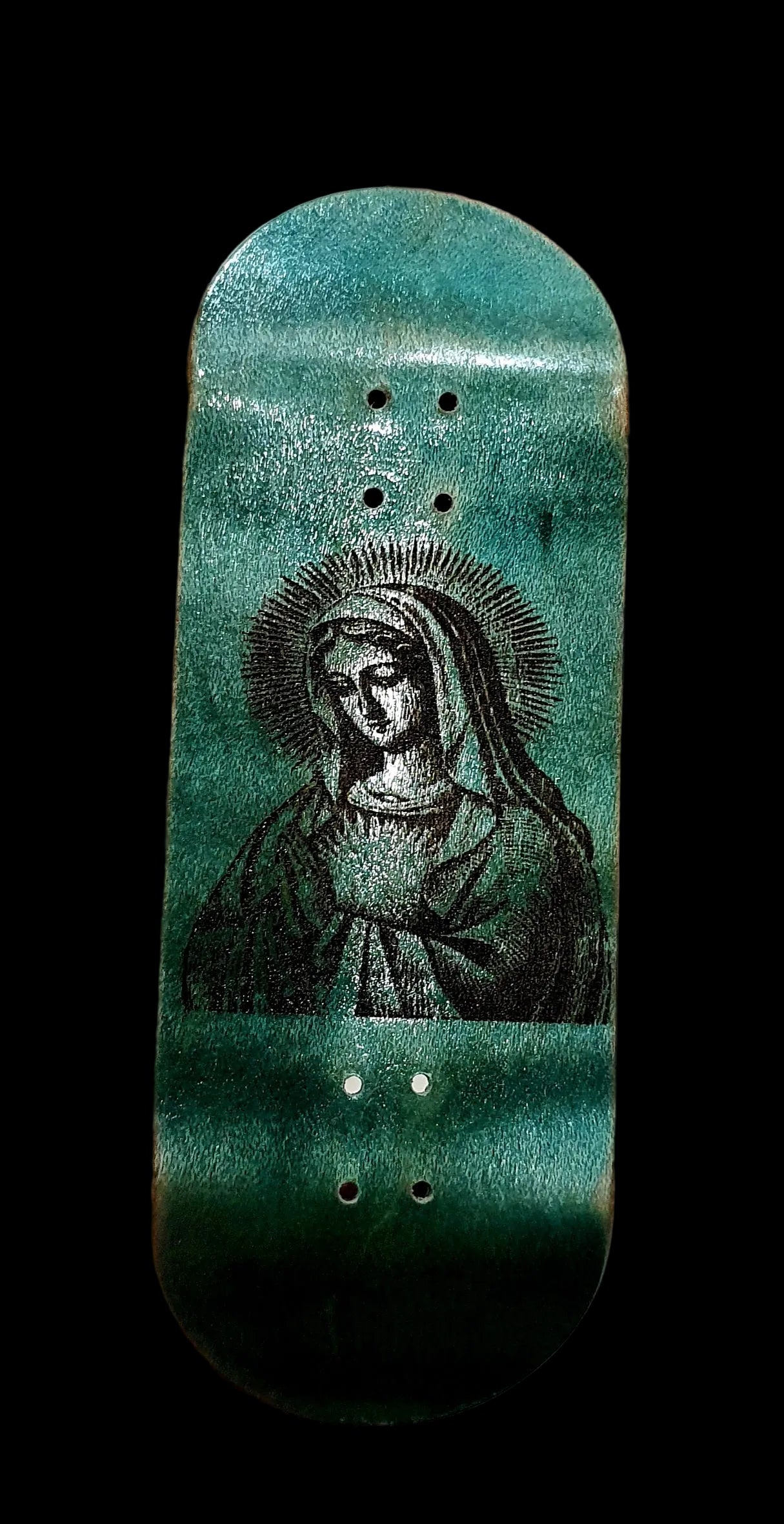 Skateboard deck with a green and black design held in a hand against a white background