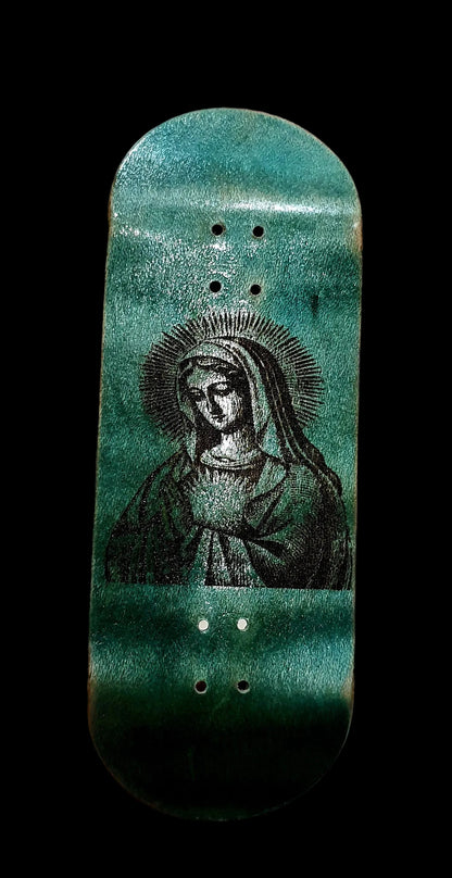 Skateboard deck with a green and black design held in a hand against a white background