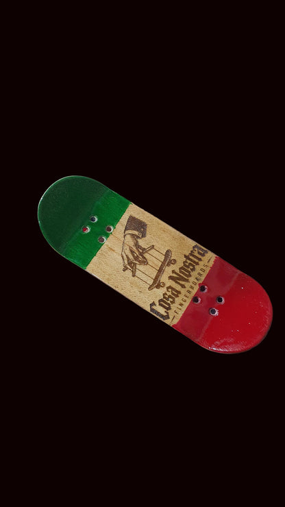 Angled tricolor fingerboard deck with green top, tan middle, red bottom and Cosa Nostra text