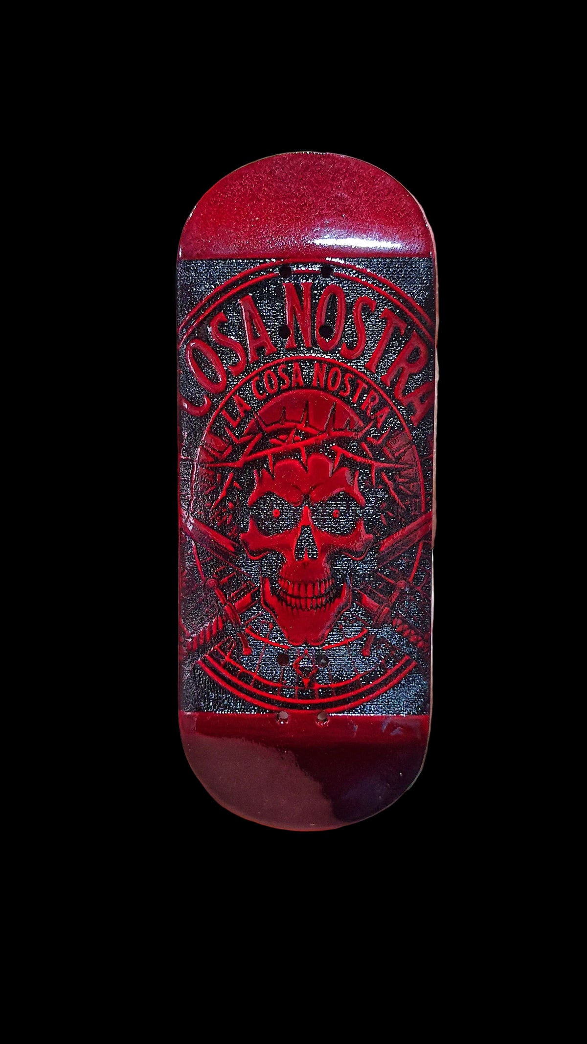 Red fingerboard deck with skull emblem and ornate black line art