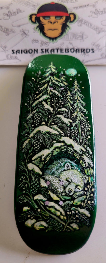 Dark green skateboard deck with night forest and moon graphic, rounded nose and tail