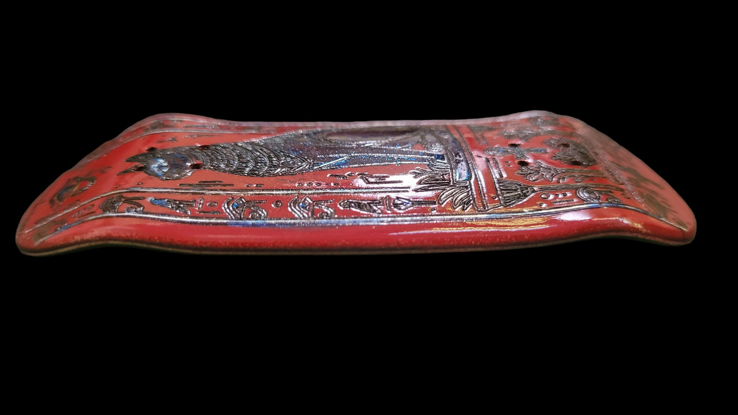 Decorative red object with intricate patterns on a dark surface