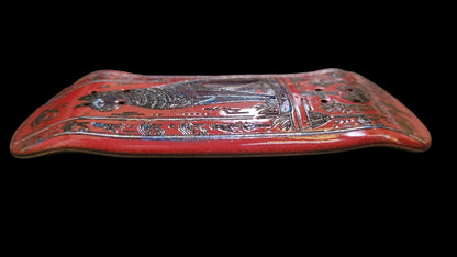 Decorative red object with intricate patterns on a dark surface