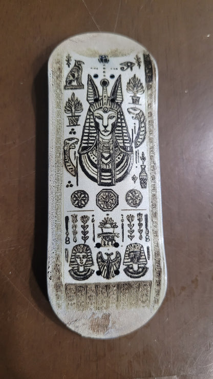 Decorative fingerboard with intricate carvings on a brown surface