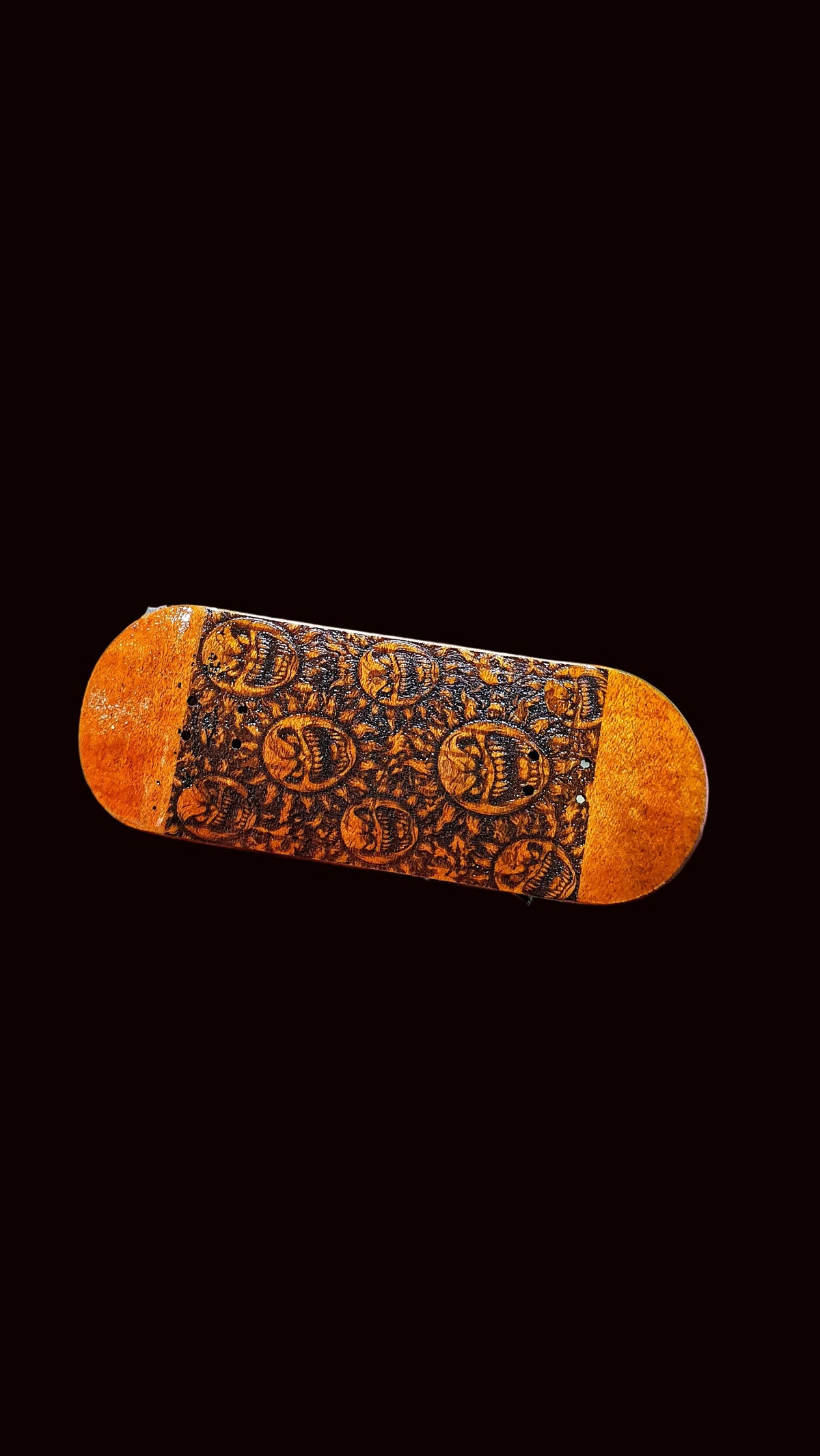 Fingerboard deck angled view, orange wood with dark patterned graphic center band