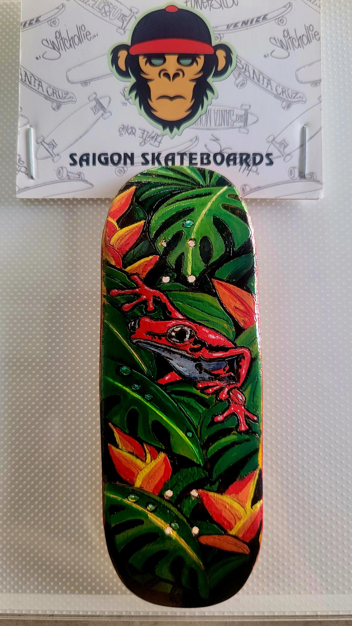 Green jungle fingerboard deck with red lizard graphic and orange leaf accents