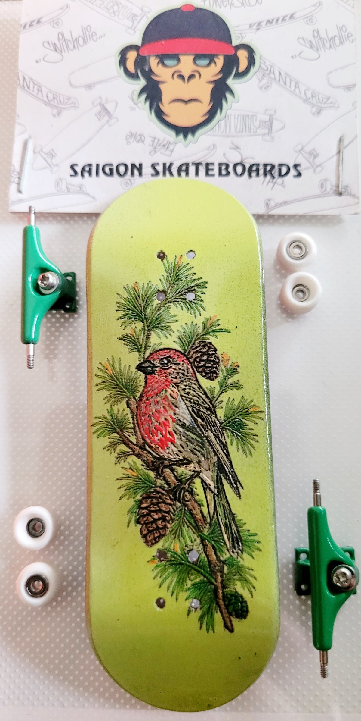 Green fingerboard complete set with bird and pine branch graphic, white wheels